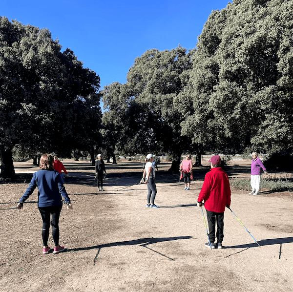 Una instructora de nordic walking enseñando a un grupo de alumnos