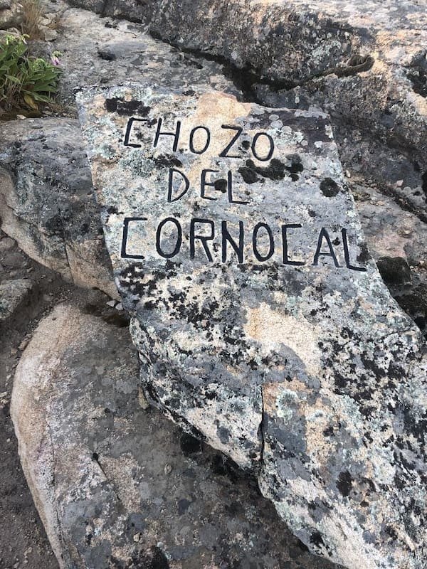 Piedra con el cartel del chozo en la ruta de marcha nórdica del chozo del cornocal